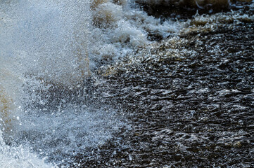 close up of flowing water, rapid water splashes of an white water river or stream, bubbly water