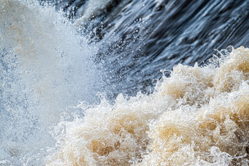 close up of flowing water, rapid water splashes of an white water river or stream, bubbly water