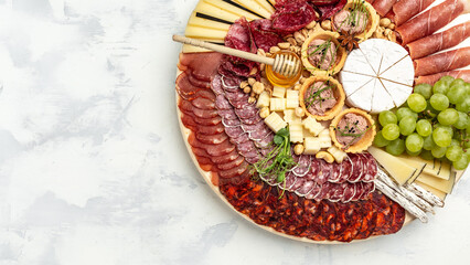 Antipasto platter of various types of soft and hard cheese. spanish manchego cheese, ham, prosciutto, jamon. Dinner or aperitivo party concept. catering banner, menu, recipe
