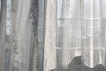 Thin white transparent curtain hanging on window at early morning in bedroom front view