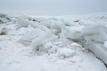 Fototapeta na wymiar Frozen sea. Huge broken ice blocks stacked up on coast. Stormy weather in Pärnu beach.