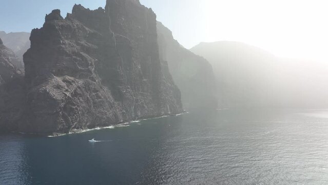 Los Gigantes steep huge cliffs rock wall bordering the blue atlantic ocean panorama seascape aerial drone footage. Tenerife, Spain, Canary islands, europe.