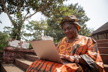 60 year old African woman uses her laptop, women and technology concept