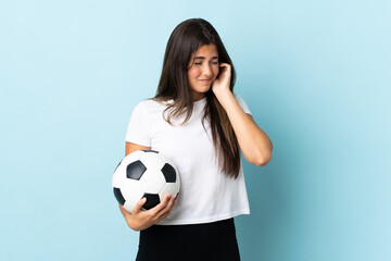 Young football player brazilian girl isolated on blue background frustrated and covering ears