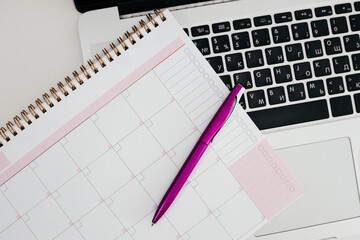 Office desk with laptop computer, planner and pen