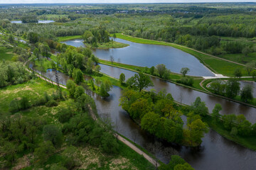 Fototapeta na wymiar A panoramic view from a height of the ponds and the Landscape Park in Peterhof, the meadow garden, walking paths, the destroyed pavilion.