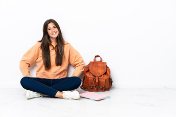 Young student brazilian woman sitting on the floor laughing