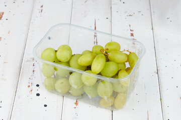 A box seedless green grapes packed in a transparent plastic box