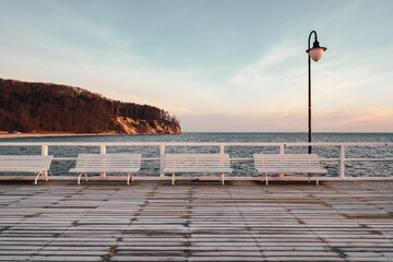 Benches on the pier with a view of the cliff and the Baltic Sea in Gdynia Orlowo. Poland - obrazy, fototapety, plakaty