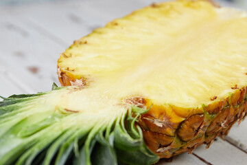Ripe and juicy pineapple on a white wooden table, pineapple half, slices, close-up