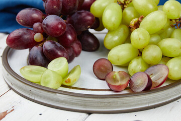 Bunches of fresh ripe green and red grapes on a wooden table