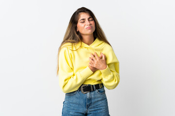 Young caucasian woman isolated on white background having a pain in the heart