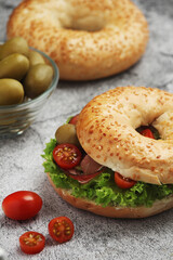 Sesame bagels with tomatoes, ham and olives	