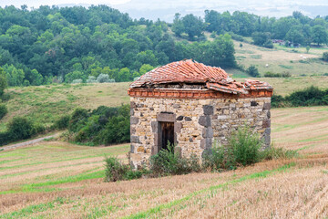 Vieille maison de vigne au milieu des champs avec son toit de tuiles oranges écroulé au bord d'un...