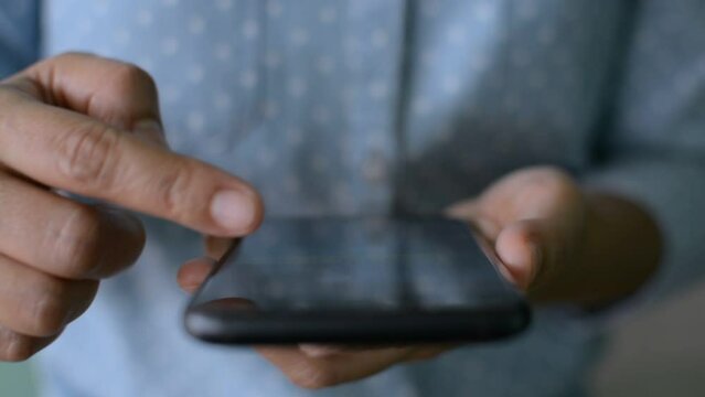 Closeup finger of woman scrolling mobile smartphone's touchscreen while watching social media online. Wireless technology. Surfing the net. Modern life with communication device.