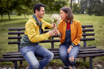 Man giving bouquet of flowers to a woman; Happy couple concept