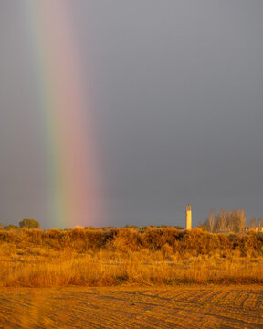 arcoiris al lado de torre de pueblo