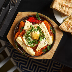 Continental breakfast. traditional greek breakfast eggs with vegetables and feta cheese in a frying pan
