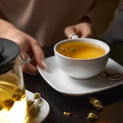 Hands Young lady preparing green tea in the kitchen in the morning