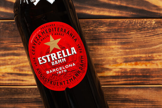 Bottle of Estrella Damm beer on wooden background with copy space	