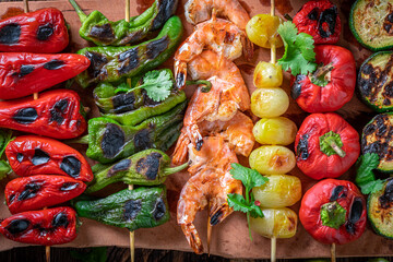 Hot roasted skewer on wooden board with spices.