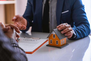 The real estate agent's home is explaining the insurance contract agreement and explaining to the client at the office. Home Loan and Insurance Concepts