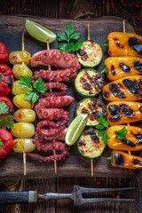 Hot roasted skewer cooking on grill with metal grate.