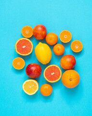 Citrus fruits: oranges, tangerines, lemons, blood oranges, on a blue background.