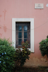 schönes altes Fenster aus Holz mit Büschen und Bäumen auf der sonnigen griechischen Insel Kreta