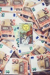 Euro banknotes and Sun tarot card