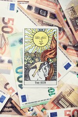 Euro banknotes and Sun Tarot card