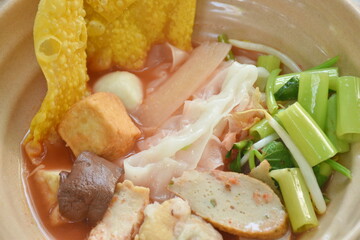 rice noodles with fish ball and tofu topping crispy squid in red soup