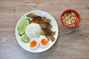 slice deep fried salty mango or Tilapia fish with rice topping boiled egg on plate dipping spicy sauce