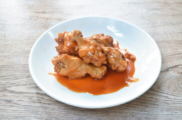 steamed chicken leg with sweet red gravy sauce on plate