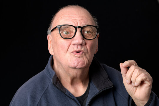 portrait homme &acirc;g&eacute; en pleine explication sur fond noir