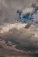 Fototapeta na wymiar piece of blue sky, enveloped by stormy clouds during twilight.