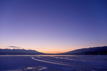Fototapeta na wymiar 1月（冬） 夜明け前の諏訪湖（一部結氷） 長野県岡谷市