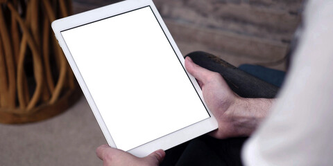 A tablet with empty white screen, close up on man hands while using an apple iPad with blank touch screen. - 489538756