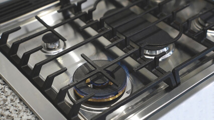 Close up of Gas stove with blue fire flames, domestic kitchen stove. - 489538761