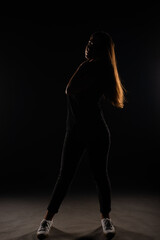 Silhouette of girl posing on grey background