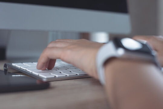 Close up, woman hands typing, working on desktop computer keyboard with digital tablet and mobile phone on table at home office