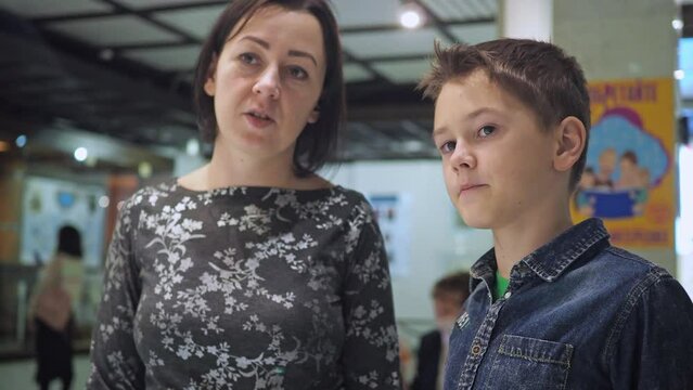 a teenager and his mother discuss the exposition in the museum. youth education