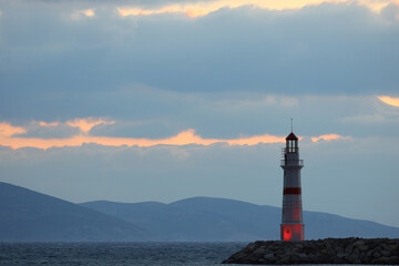 Seascape at sunset. Lighthouse on the coast	

