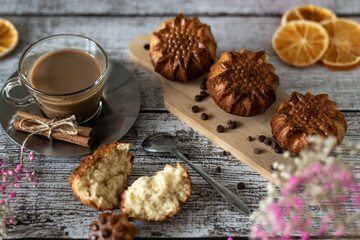 Delicious festive breakfast homemade muffins and a cup of latte coffee on a wooden light background, close-up