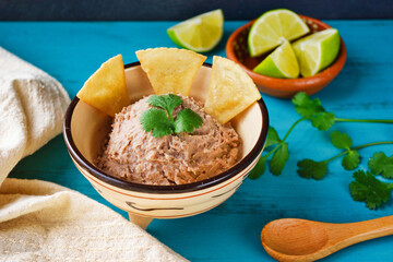 青背景のメキシコのフリホーレス・レフリートス　トトポスをそえて　コピースペースあり Mexican Frijoles Refritos (Mexican Refried Beans) with Totopos on blue background with copy space