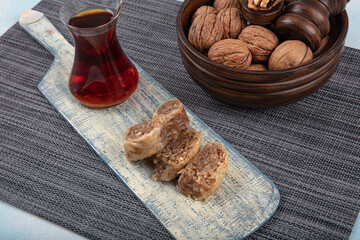 Traditional Turkish dessert walnut baklava with walnuts and tea on a wooden table. Food cake background. Turkish traditional Walnut Baklava dessert and tea concept.