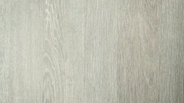 Hand holding wood grain laminate material to compare the color with the wood on the built-in cabinet. in selecting materials for construction to satisfy the residents