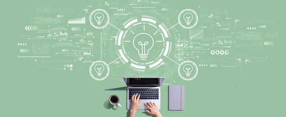 Idea light bulb theme with person working with a laptop