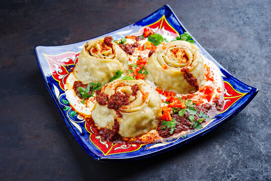 Traditional Afghan ay khanom steamed with mincemeat, paprika and yogurt as close-up on a classic plate