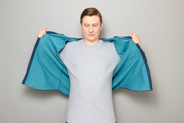 Shot of mature man opening shirt, fanning himself with shirt to cool